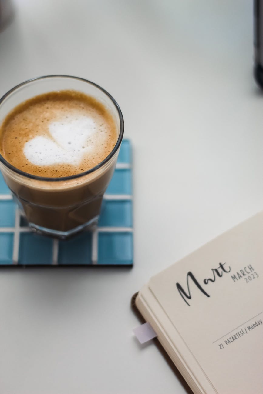 glass of coffee by a planner